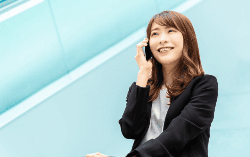 スマホで笑顔で通話する女性